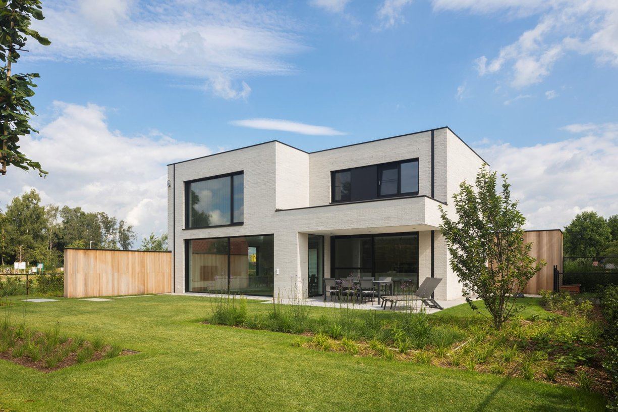 Moderne nieuwbouwwoning met grote ramen en tuin